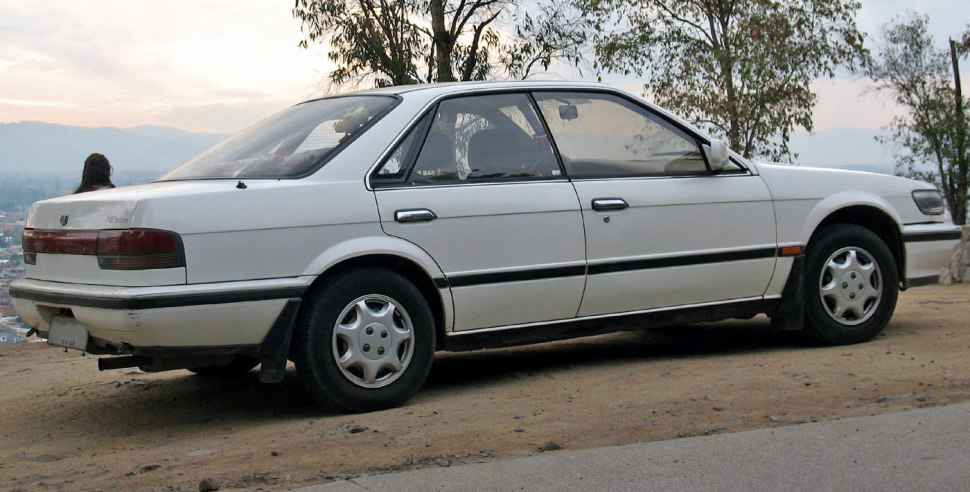 Rear side profile of vintage 1980s sedan with classic design.