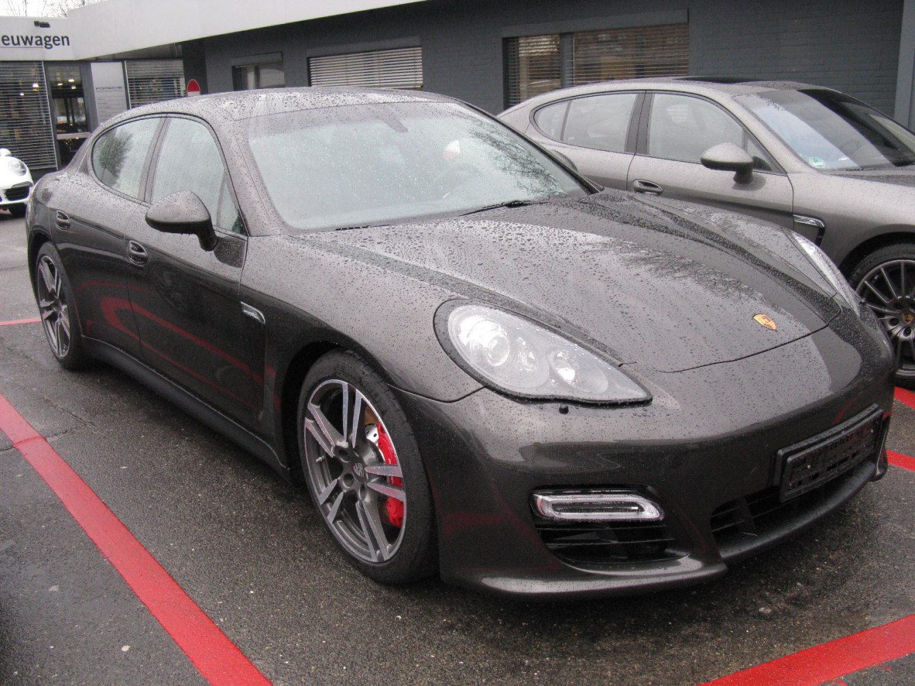 Wet Porsche Panamera front with alloy wheels and LED lights