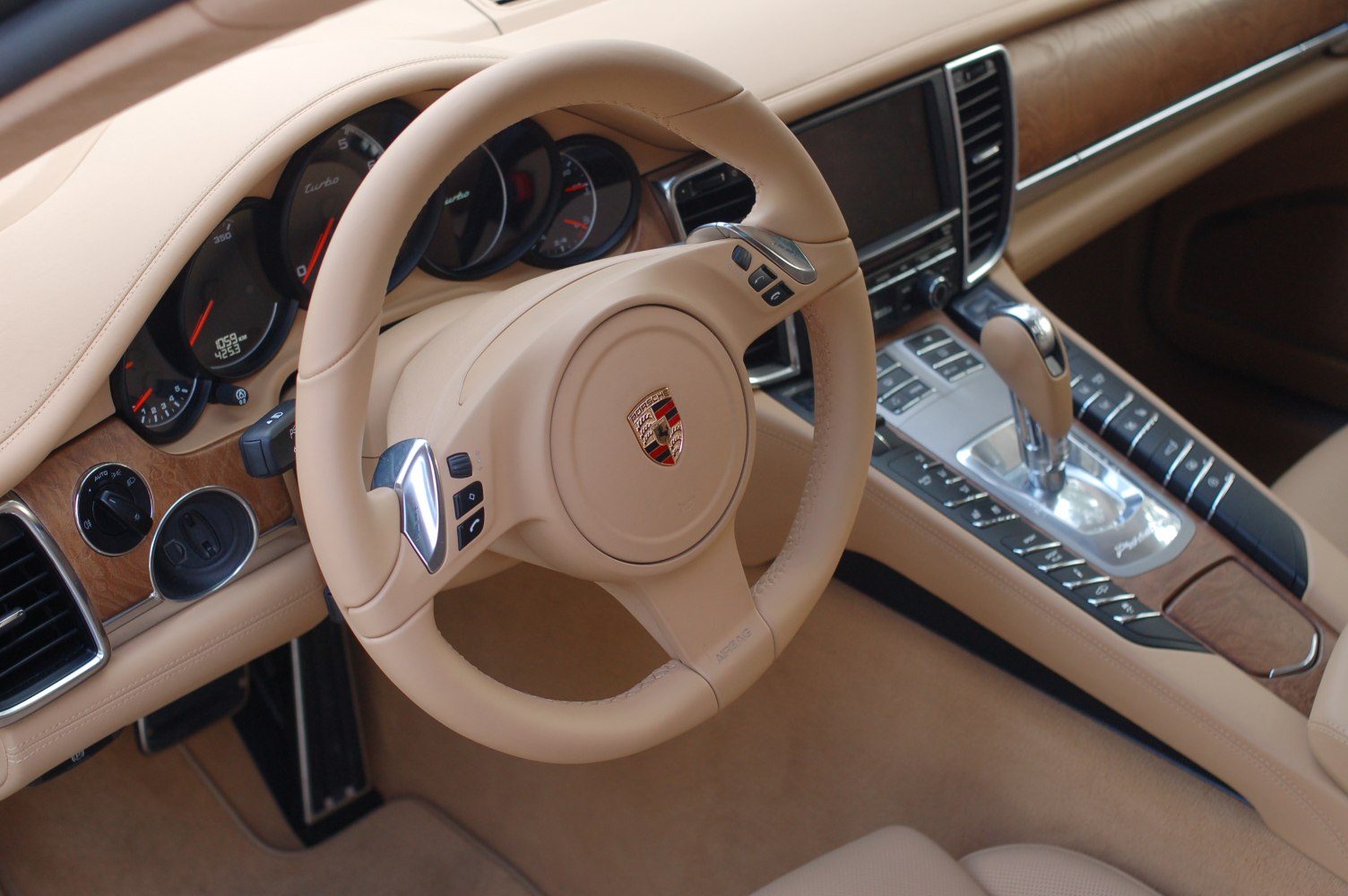 Luxury steering wheel and center console with gear shifter in beige interior