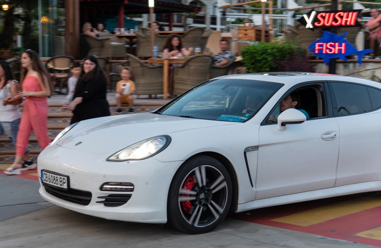 White luxury sedan front side view with alloy wheels and red brake calipers