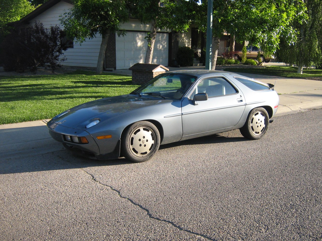 Front side profile with pop-up headlights and sleek silver coupe design
