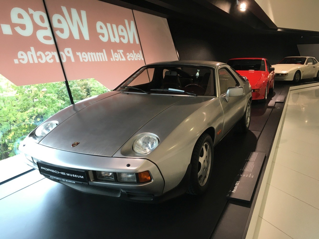 Silver Porsche 928 with pop-up headlights displayed indoors