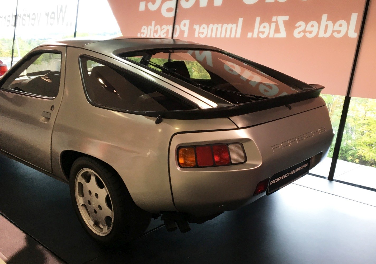 Rear view of a sloped hatchback with distinctive Porsche-style taillights