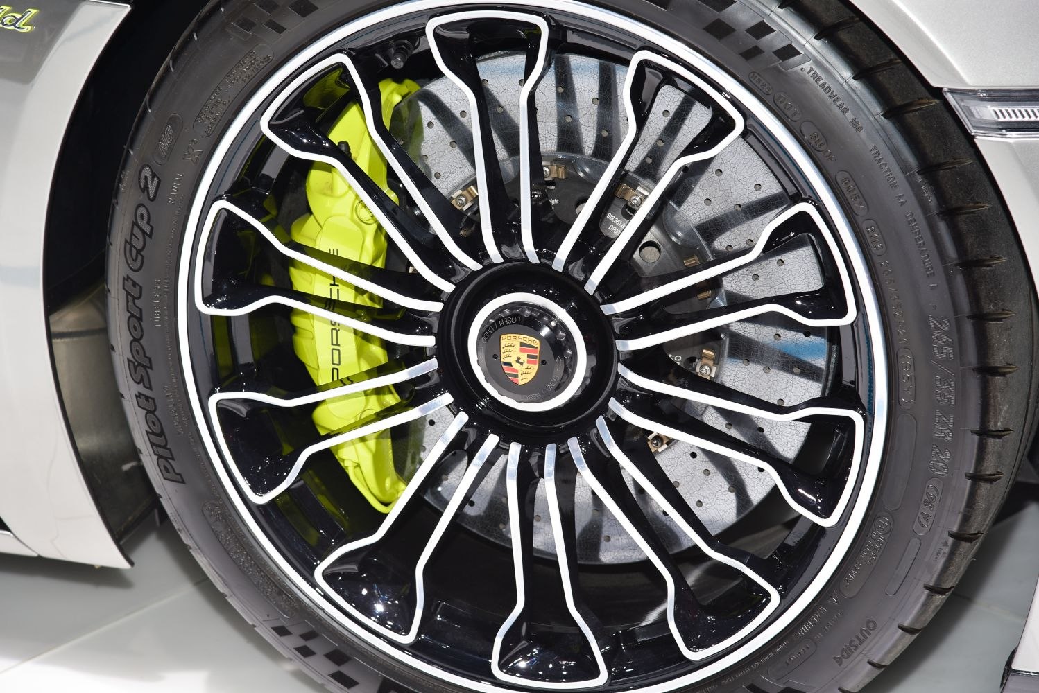 Black alloy wheel with white accents and neon yellow brake caliper