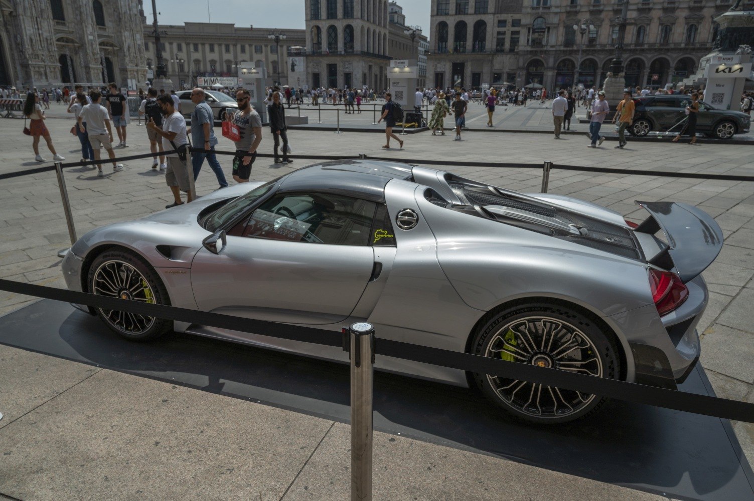Silver sports car with rear wing and distinctive alloy wheels