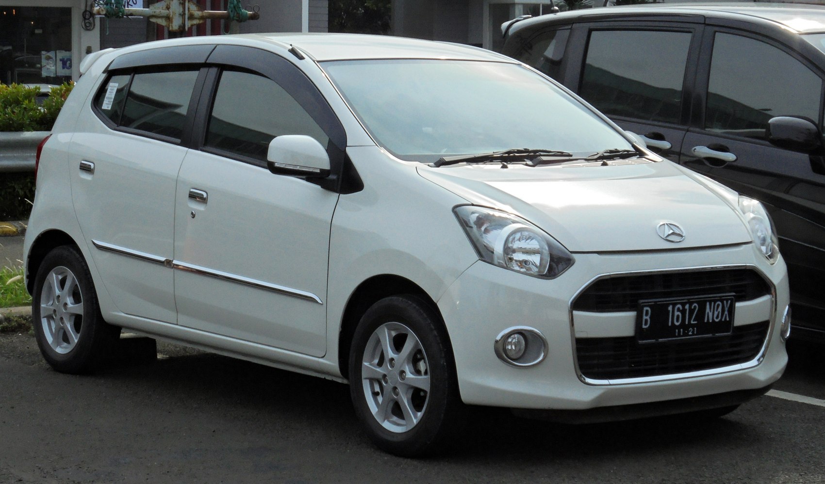 Compact white hatchback with large front grille and alloy wheels.