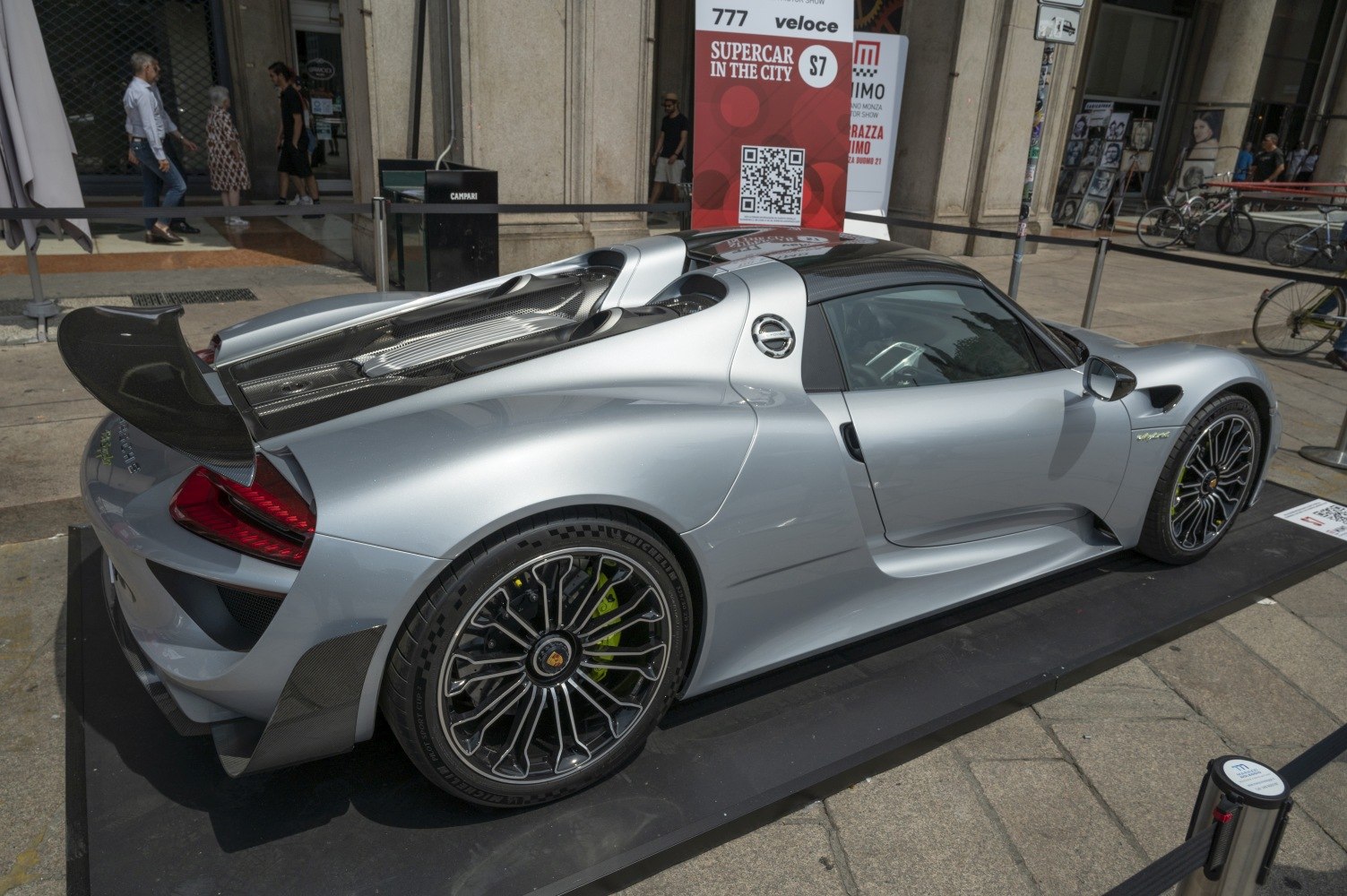 Silver supercar rear three-quarter view with carbon fiber wing and detailed wheel design