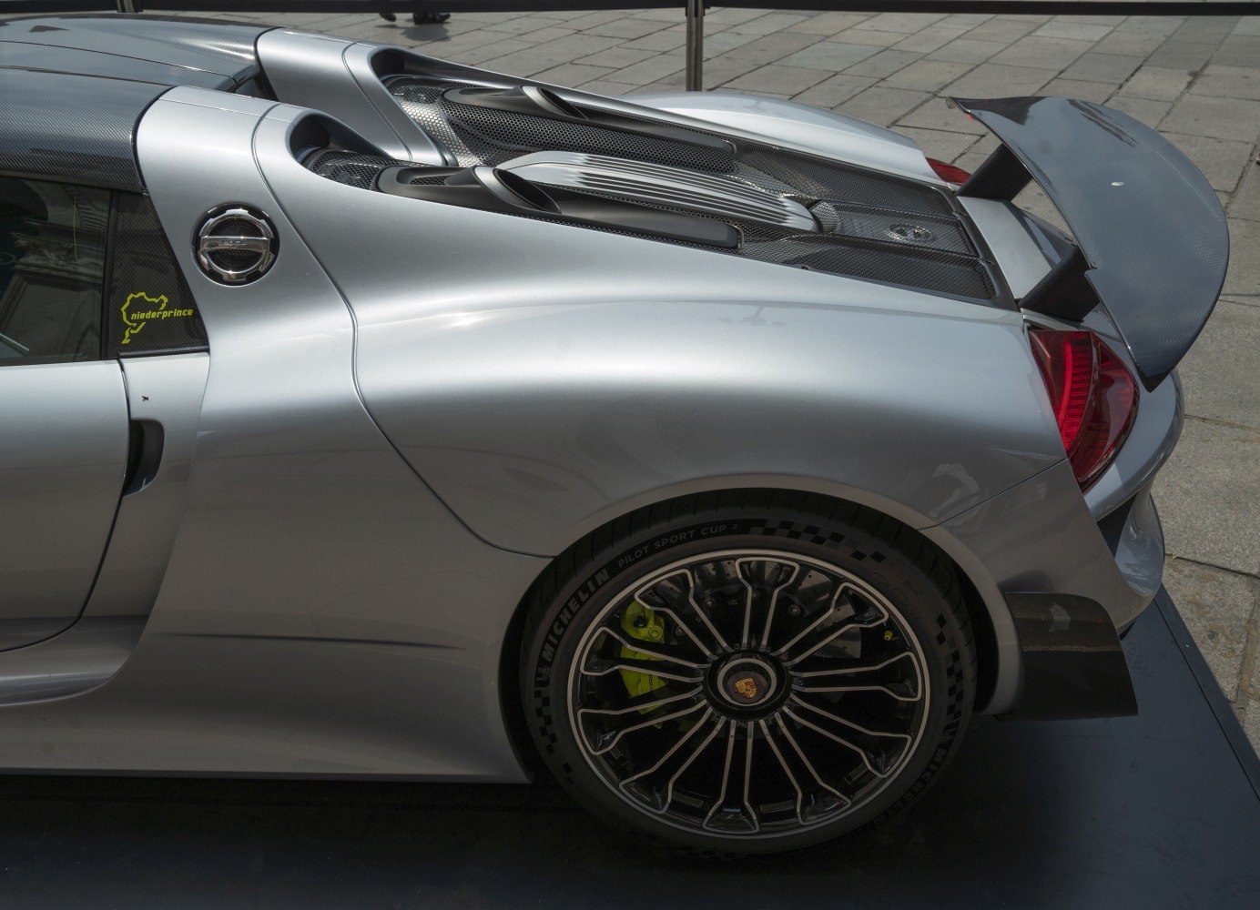 Rear side view with carbon fiber spoiler and detailed alloy wheel