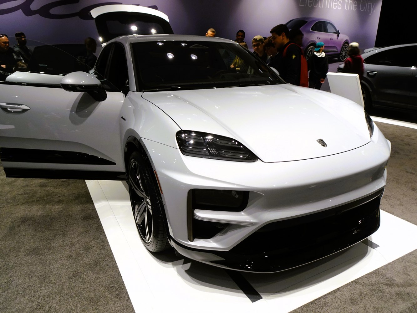 Front and side view with open door of white luxury electric SUV