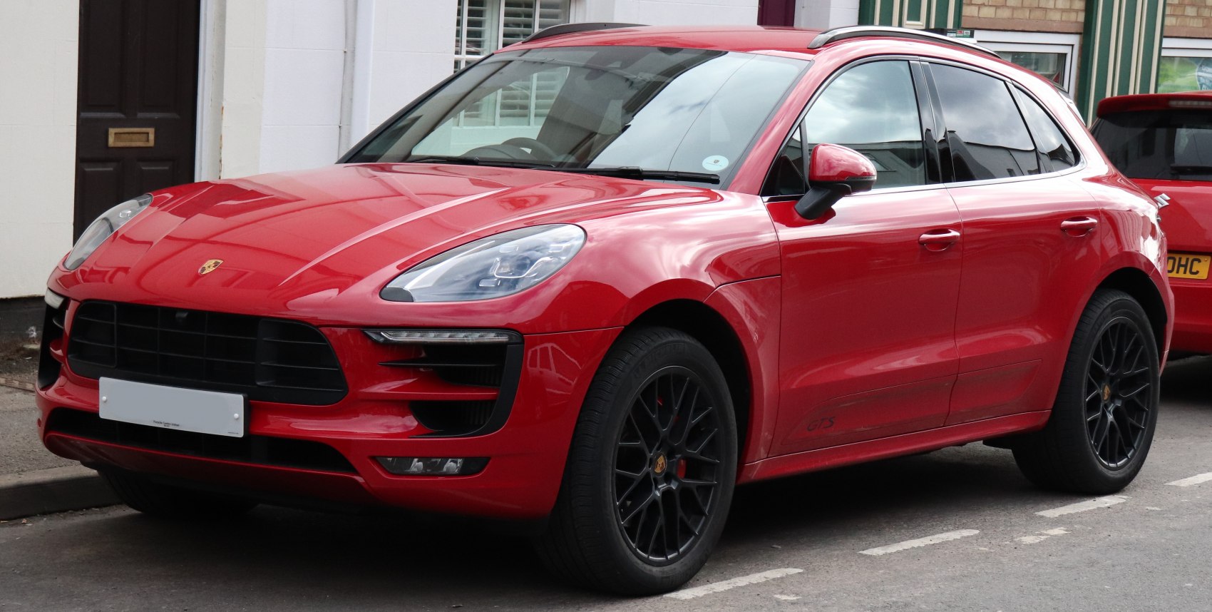 Red SUV with sharp headlights and sporty black alloy wheels