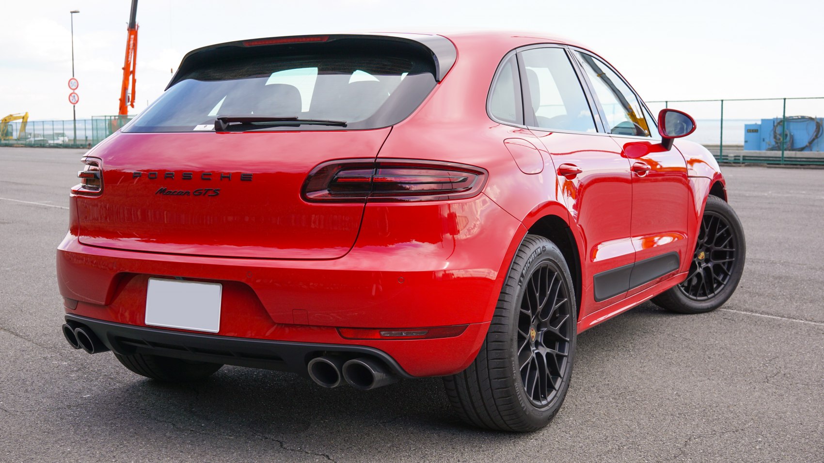 Rear view of red SUV with black multi-spoke wheels and quad exhaust pipes