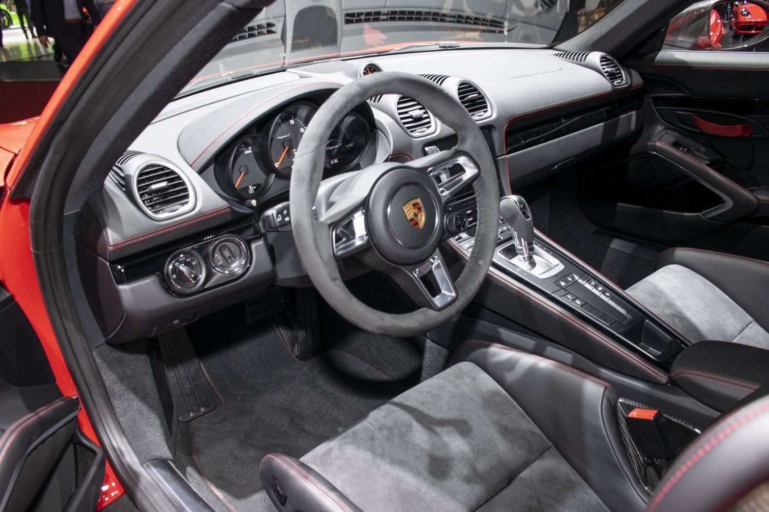 Sporty steering wheel and modern dashboard with instrument cluster and gear shifter.