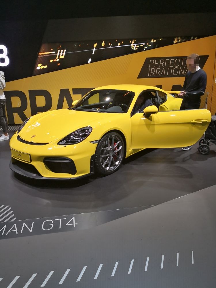 Yellow sporty coupe with open door and racing design elements.