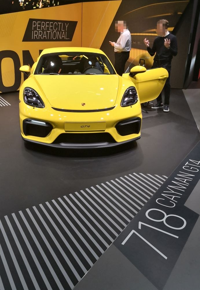 Front view of yellow sports coupe with open door and aggressive headlights