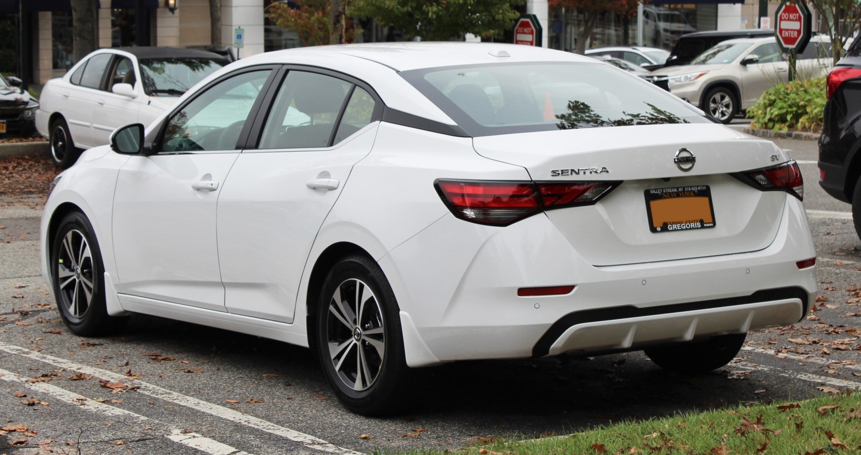 Rear view of a white sedan with distinctive angular taillights and sporty rear bumper trim.