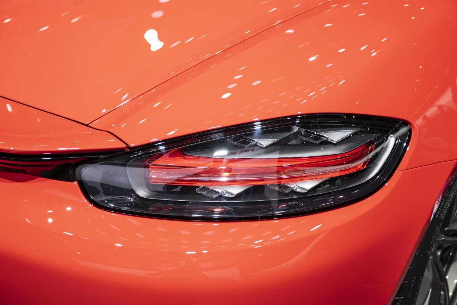 Close-up of sleek tail light and rear body panel in orange.