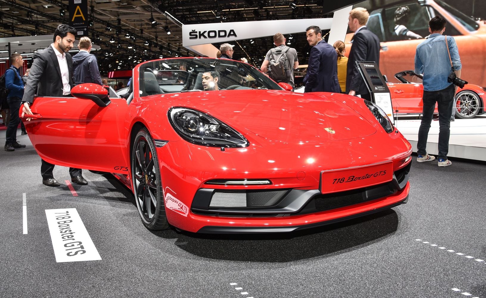 Red convertible sports car with black wheels and aerodynamic front design
