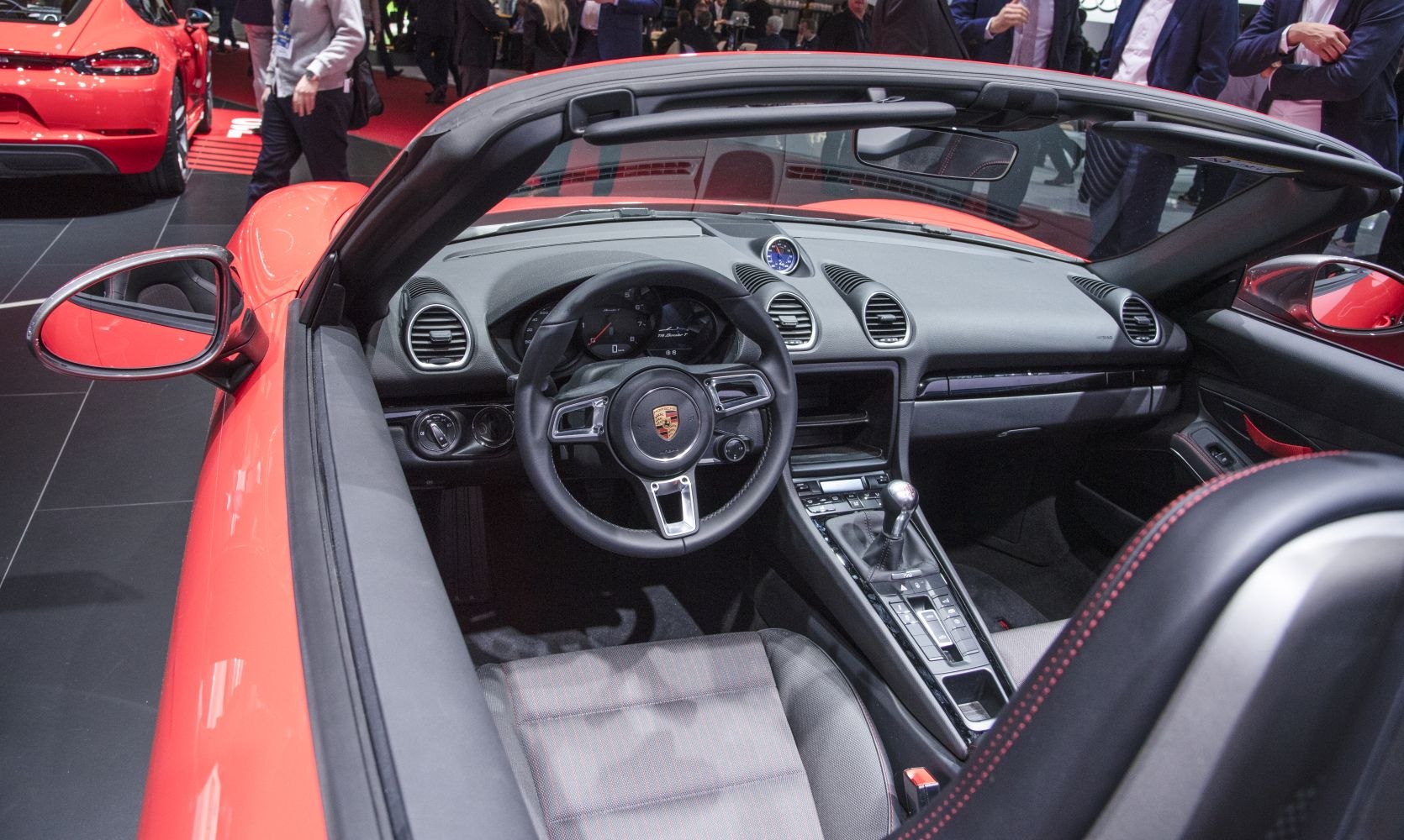 Convertible interior with steering wheel, dashboard, and manual gear shifter