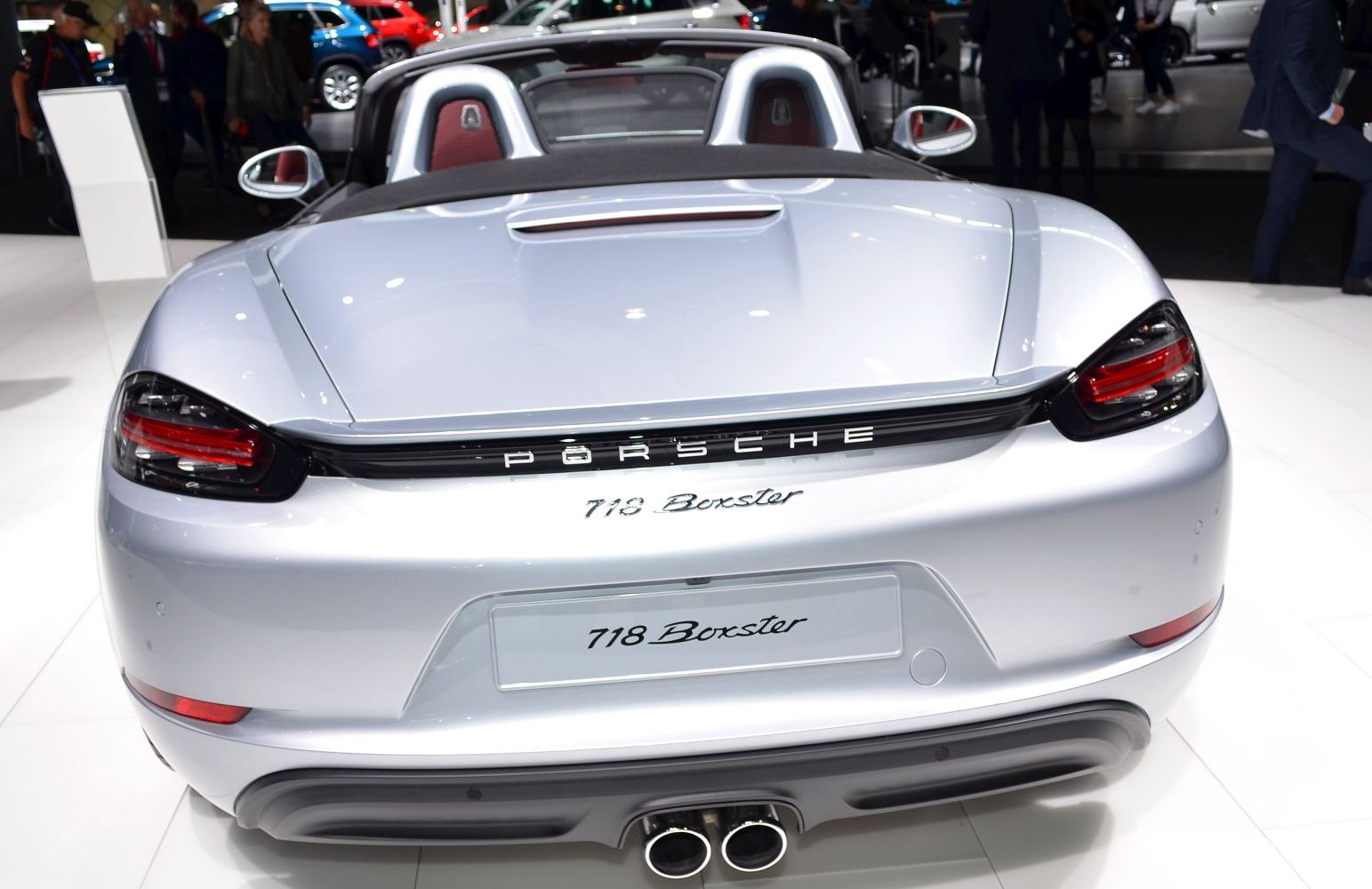 Rear view with distinctive tail lights and dual exhaust of silver convertible