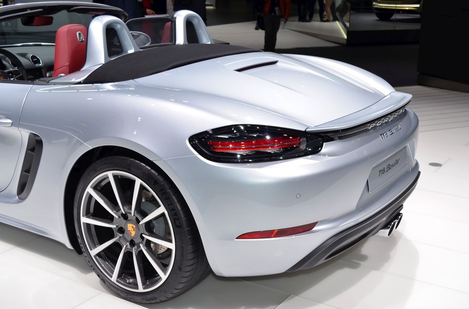 Rear section of a convertible sports car with tail lights and alloy wheels