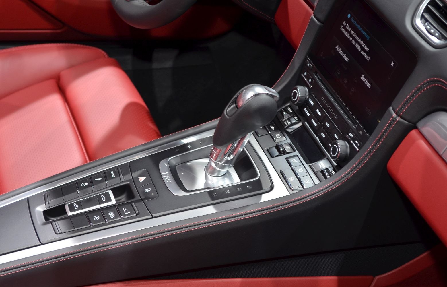 Center console with gear shift and control buttons in red leather interior