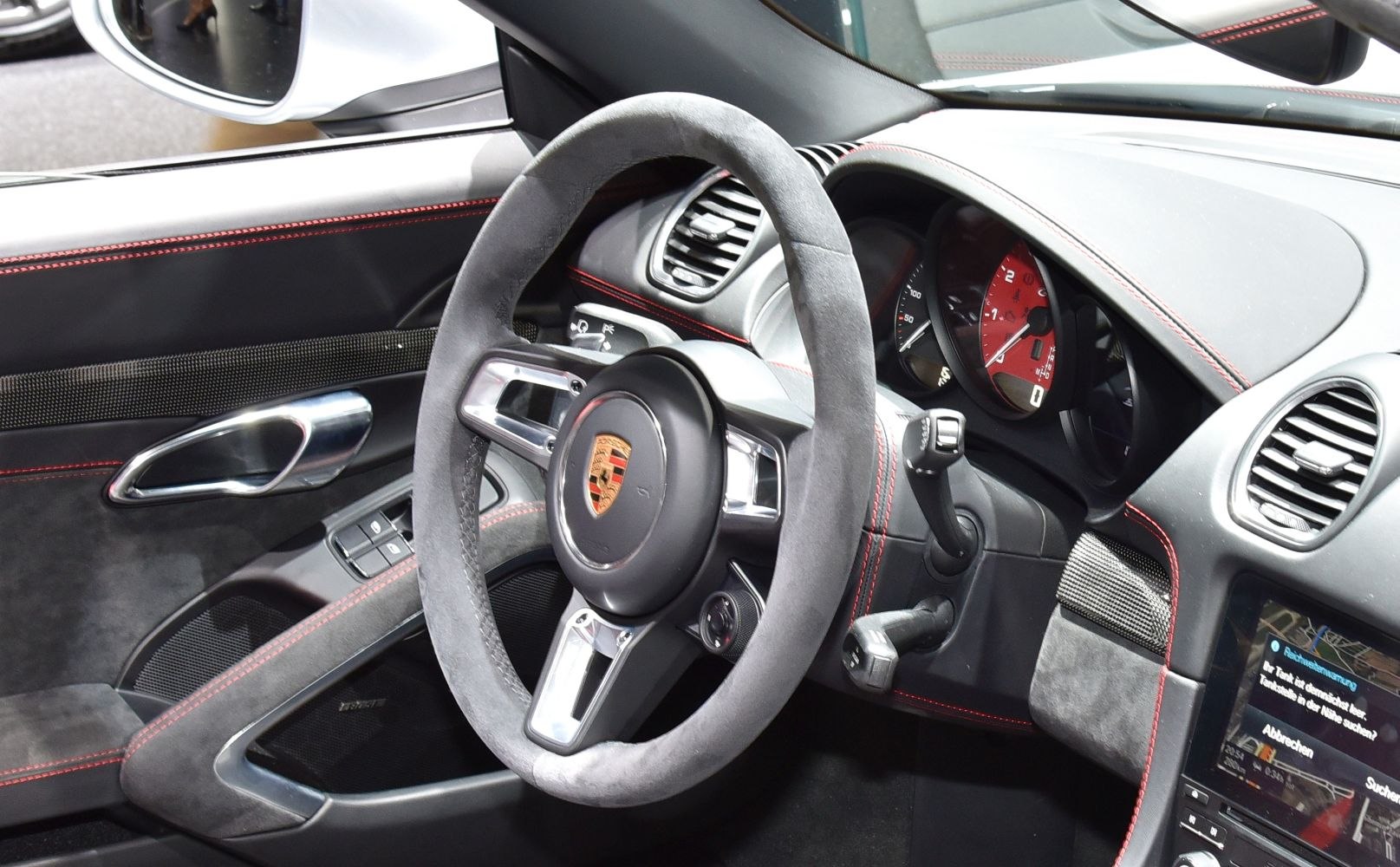 Alcantara steering wheel with red stitching and dashboard gauges
