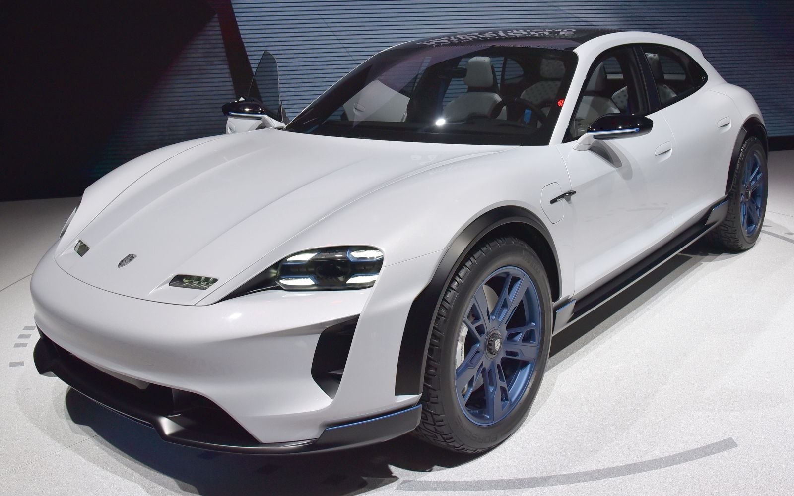 Sleek front angle with distinctive headlights and blue rims