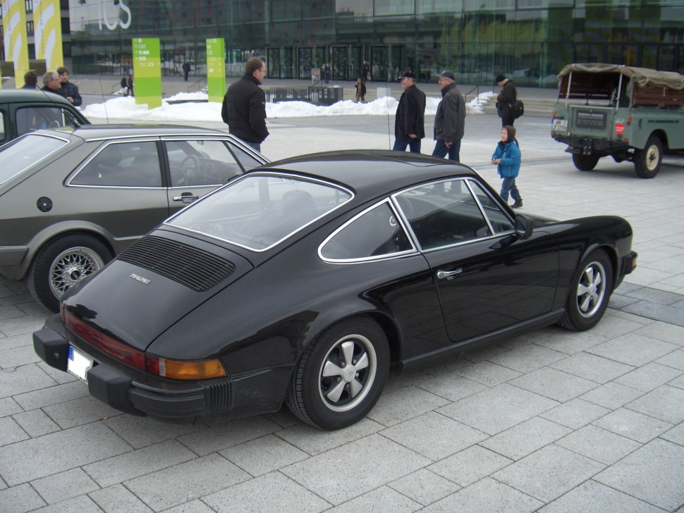 Rear angle of black vintage sports coupe with Fuchs wheels