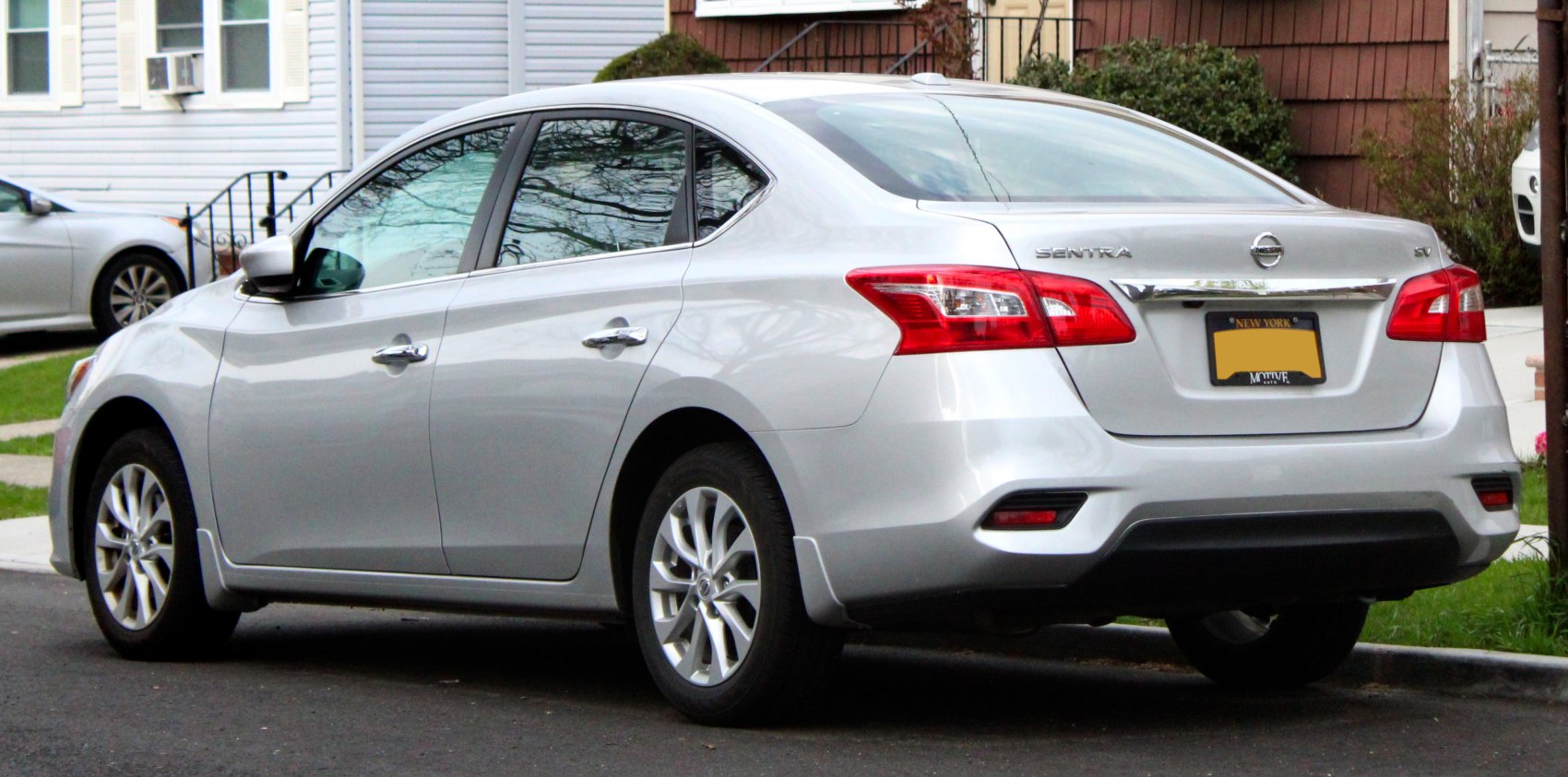 Rear side view of silver sedan with distinct tail lights and alloy wheels