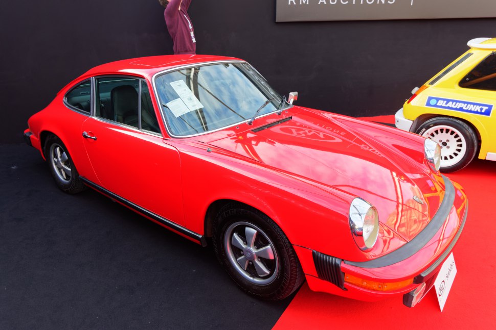 Red classic coupe with round headlights and vintage styling