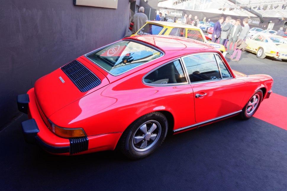 Rear and side profile of a classic vintage sports coupe in bright red.