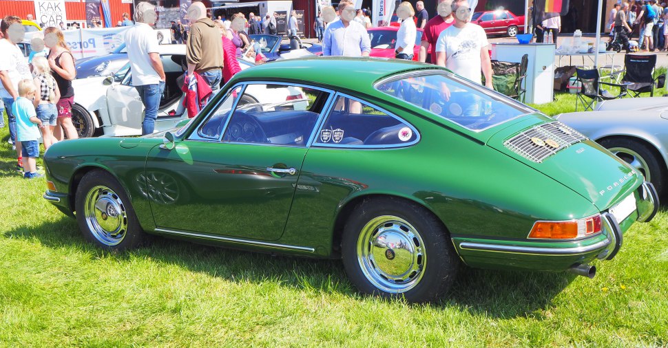 Side profile of a vintage sports coupe with polished hubcaps and streamlined design
