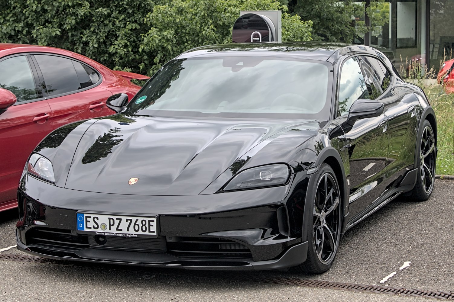 Black electric sporty hatchback with aerodynamic design and sharp headlights.