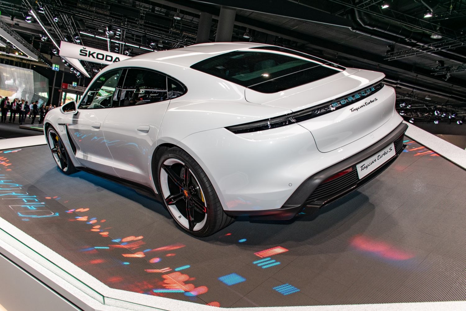Rear view of a sleek electric sedan with sporty large alloy wheels.