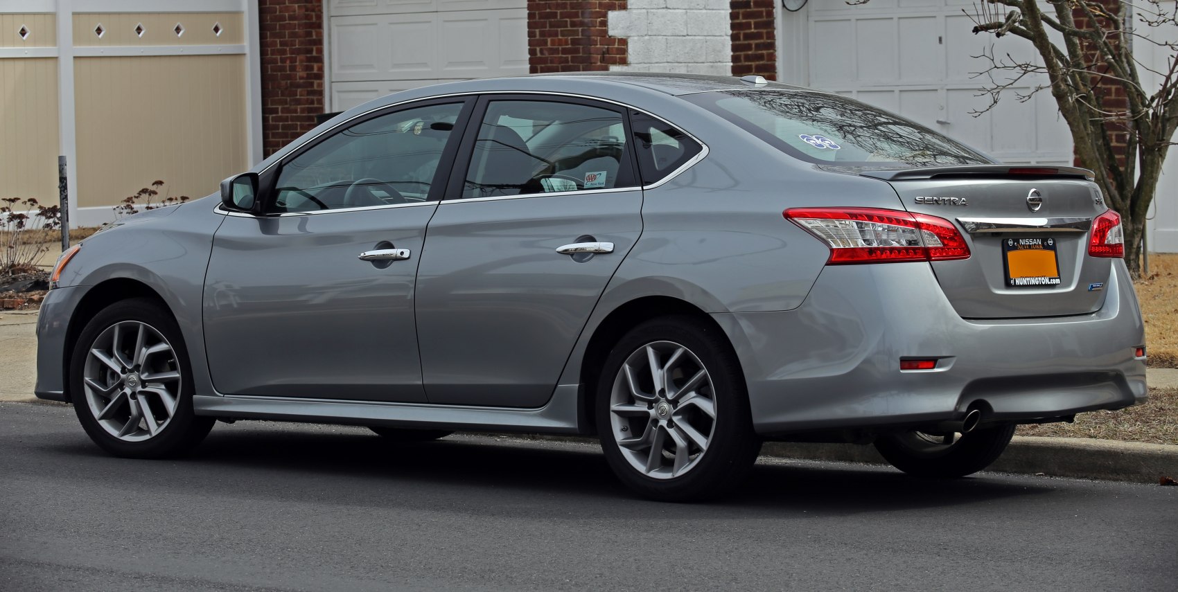 Silver sedan rear-side view with alloy wheels and sleek design