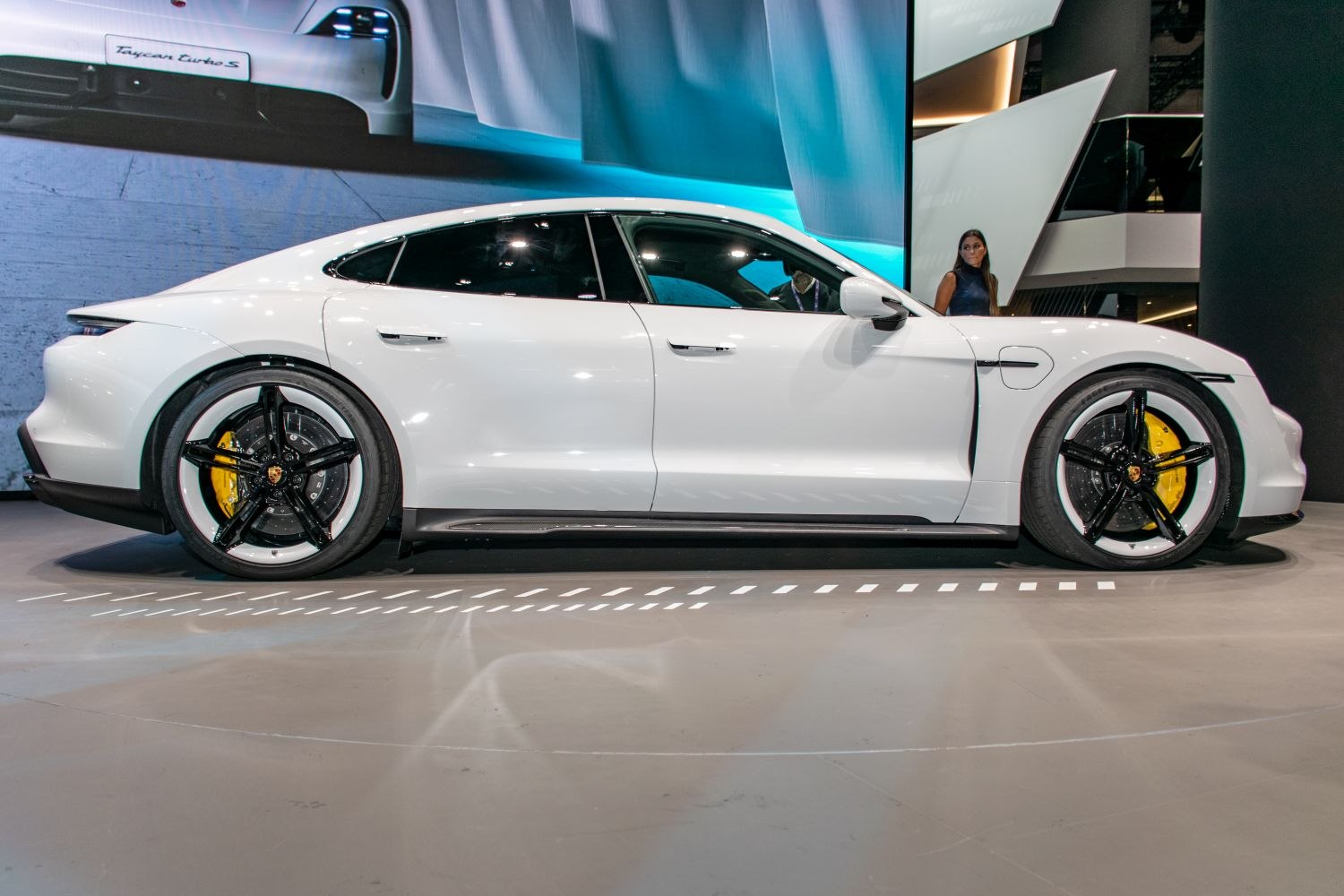 Side profile of sleek electric sedan with distinctive black rims and yellow brake calipers