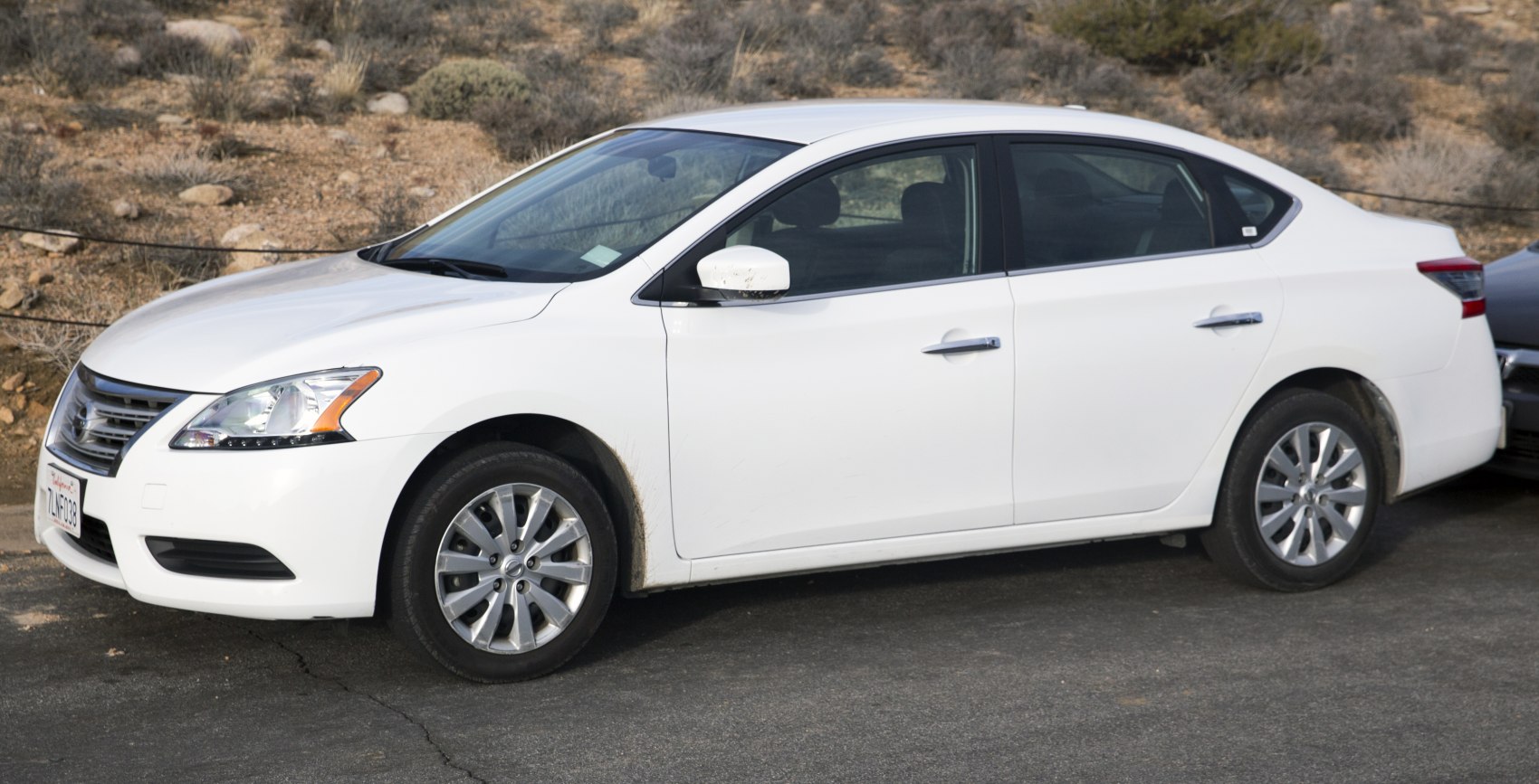 Side profile of sedan with alloy wheels and distinctive body shape
