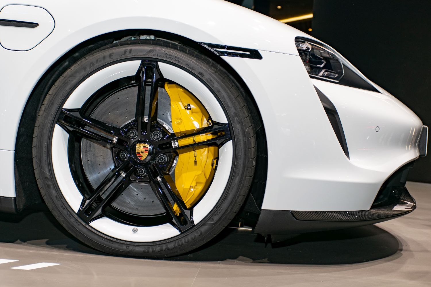 Black and white alloy wheel with yellow brake caliper on sports sedan