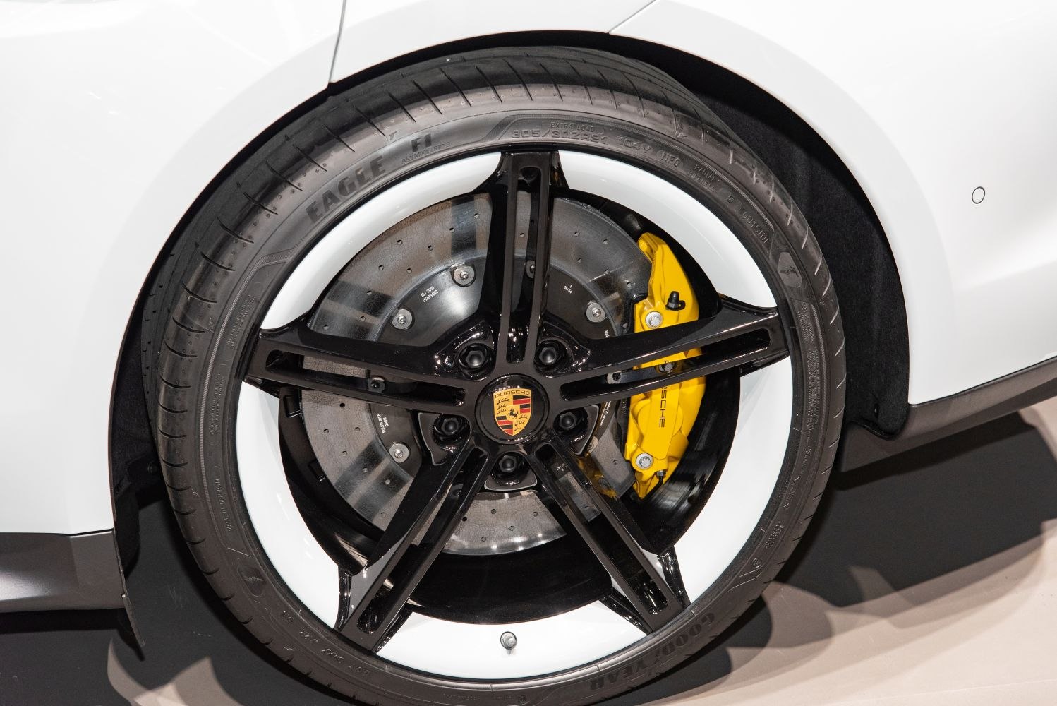 Black five-spoke wheel with yellow brake caliper