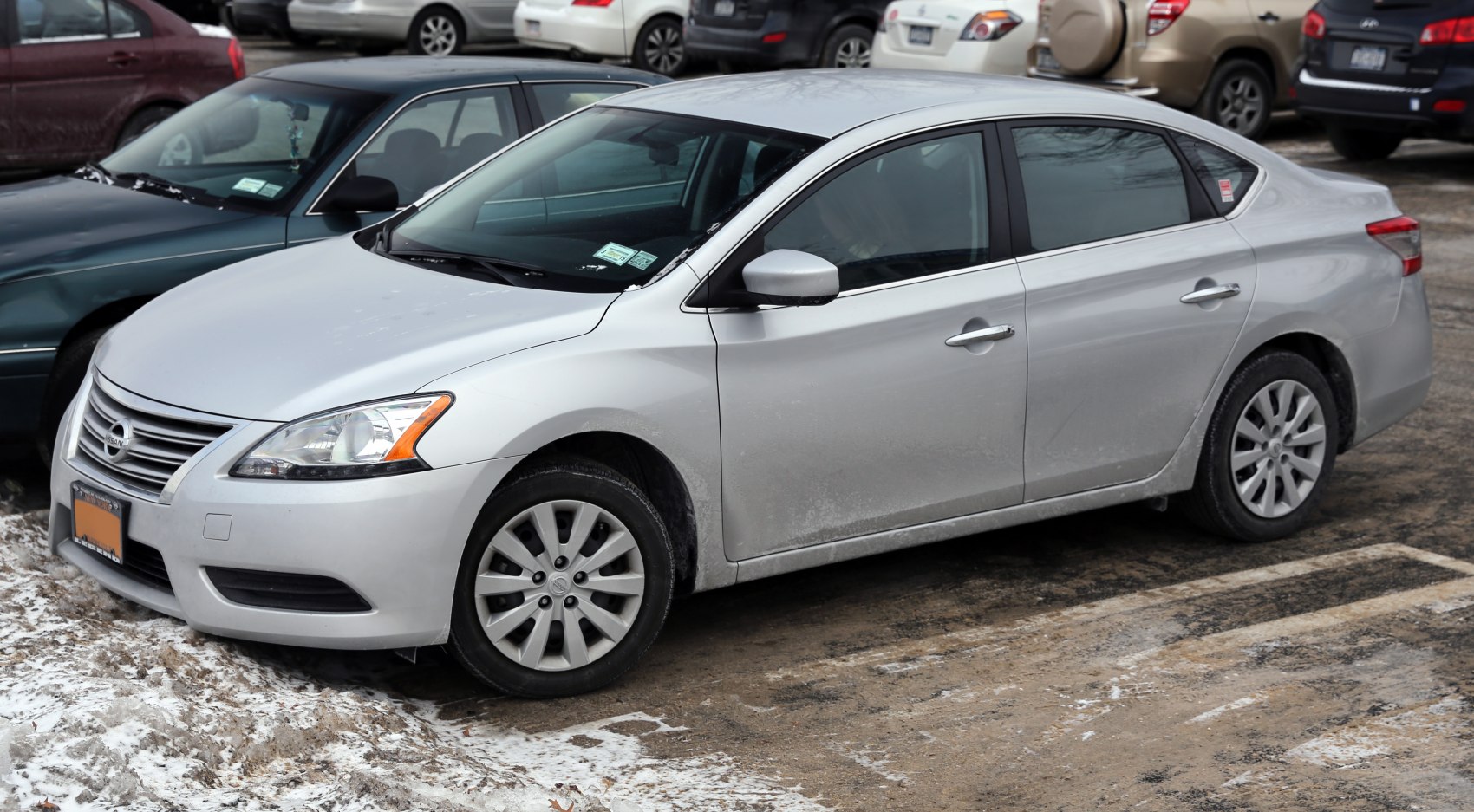 Silver sedan parked on snowy muddy ground