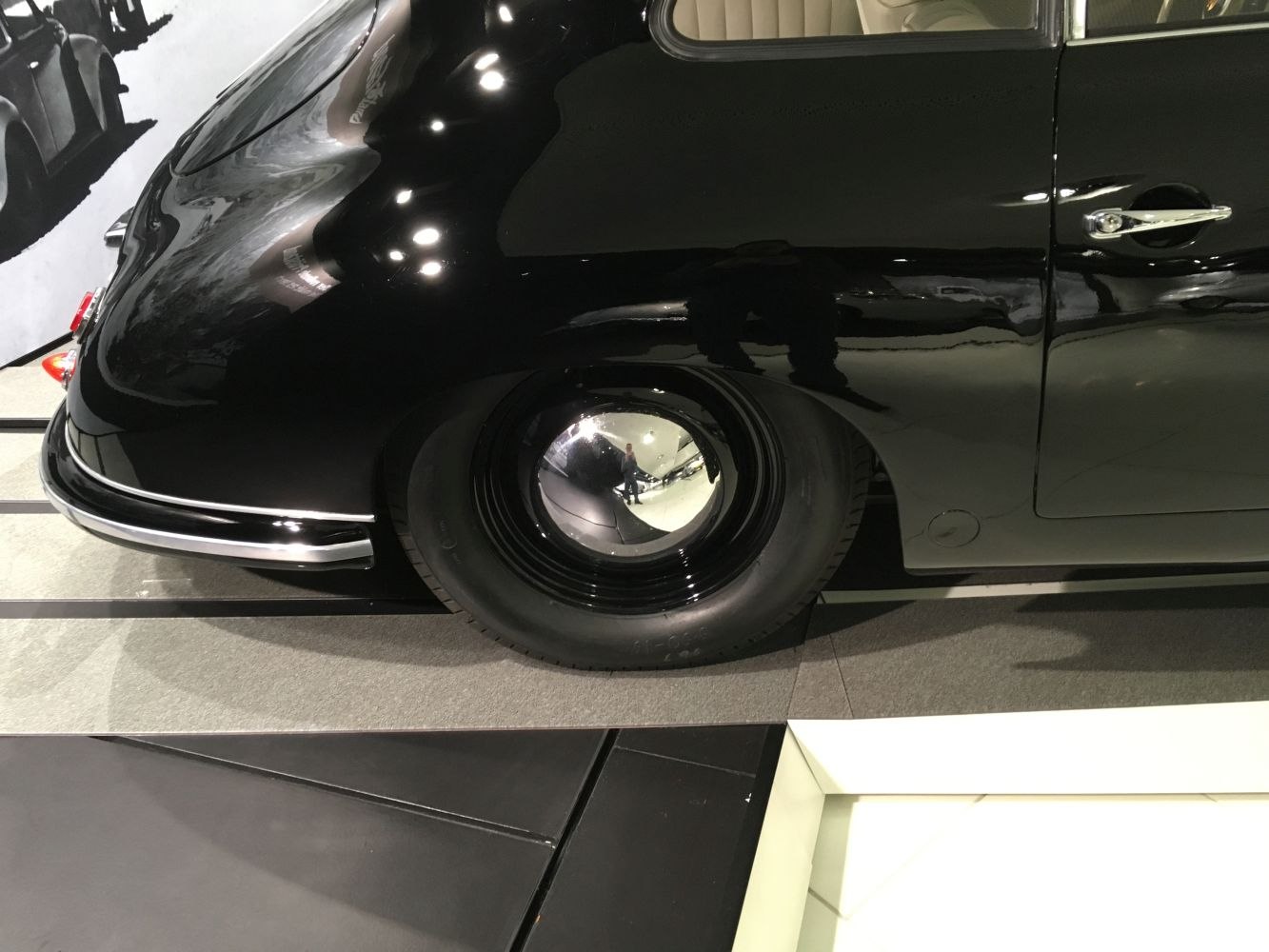 Glossy rounded rear fender with shiny hubcap wheel and door handle