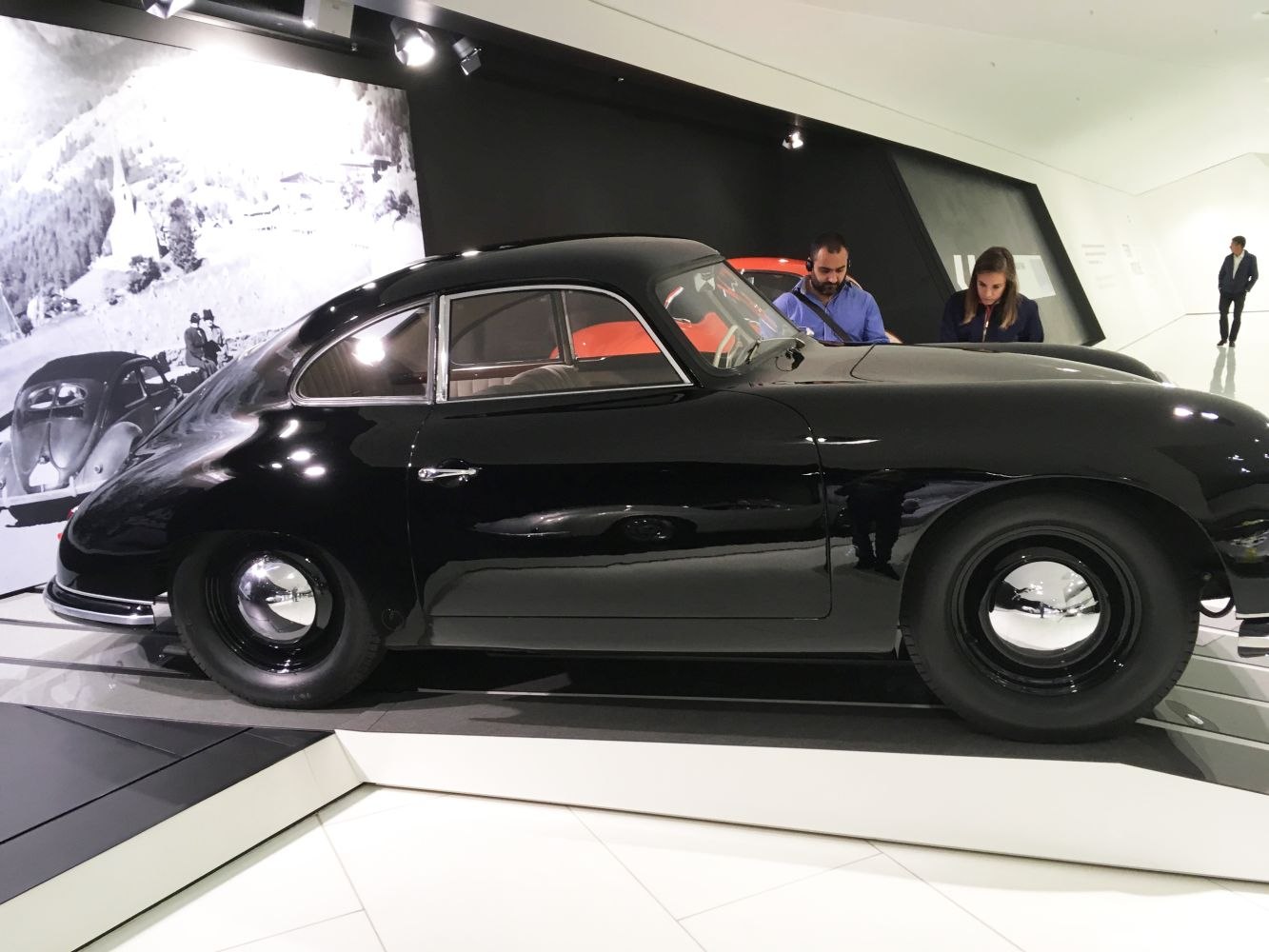 Sleek black vintage coupe with curved body and retro hubcaps