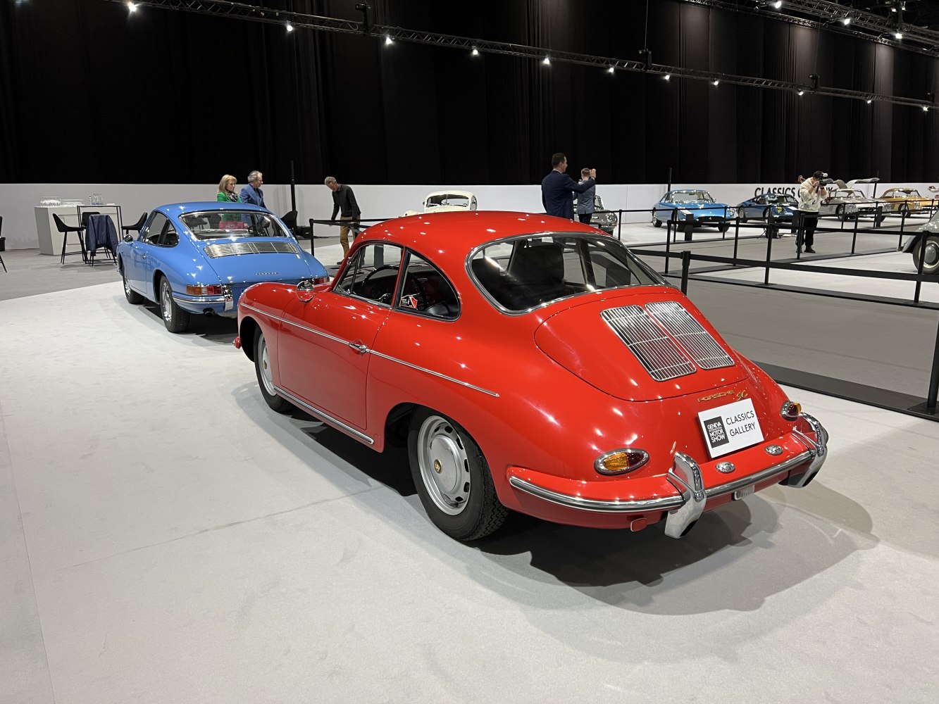 Rear views of classic coupe sports cars with distinct rear-engine vents.
