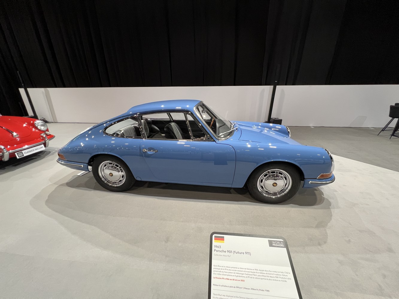 Blue classic coupe with round headlights and chrome wheels.