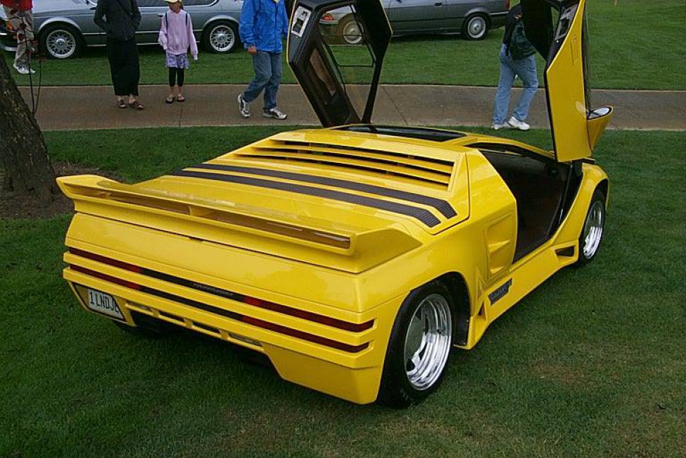 Yellow sports car with scissor doors and rear spoiler