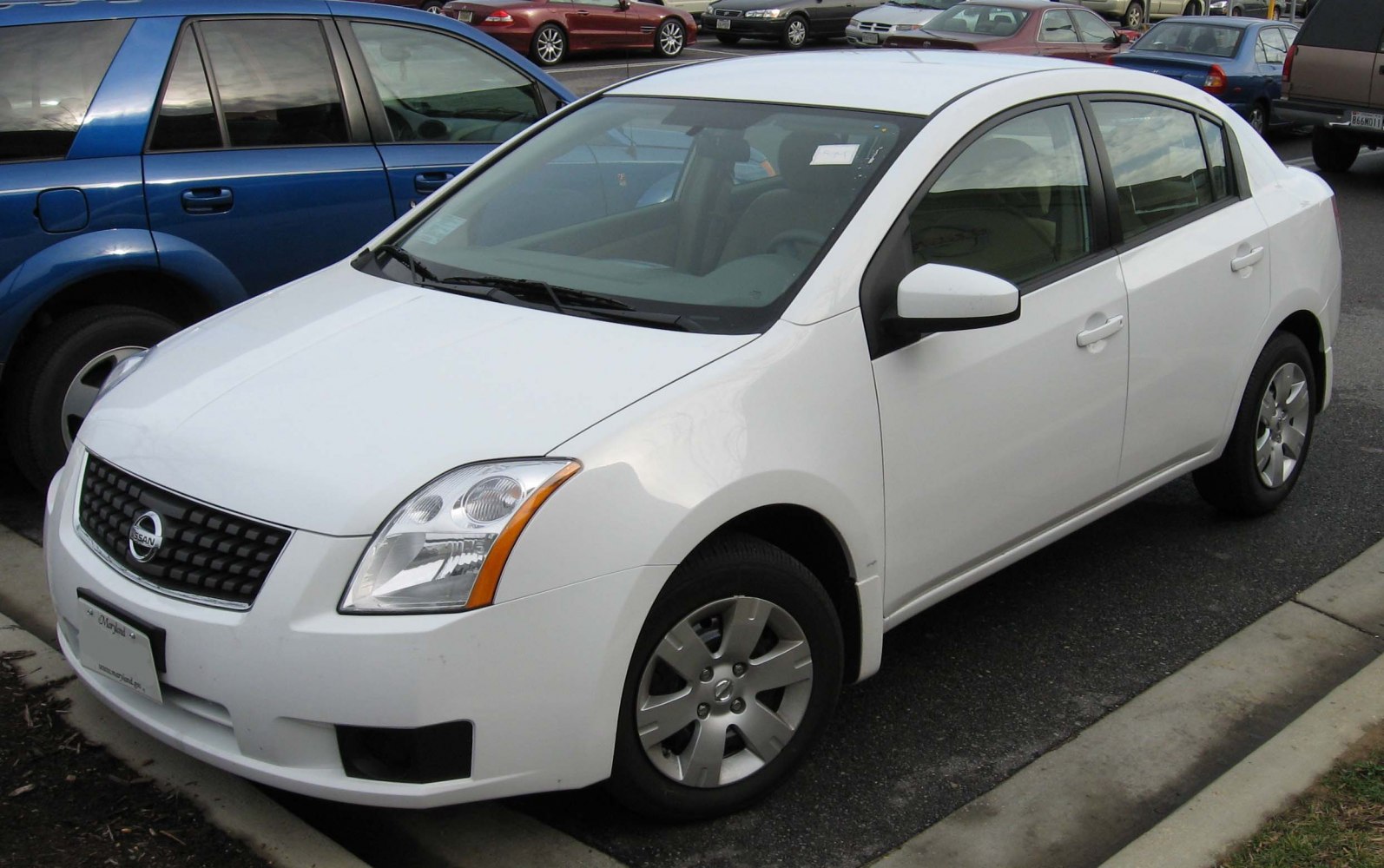 White compact sedan front side view with alloy wheels