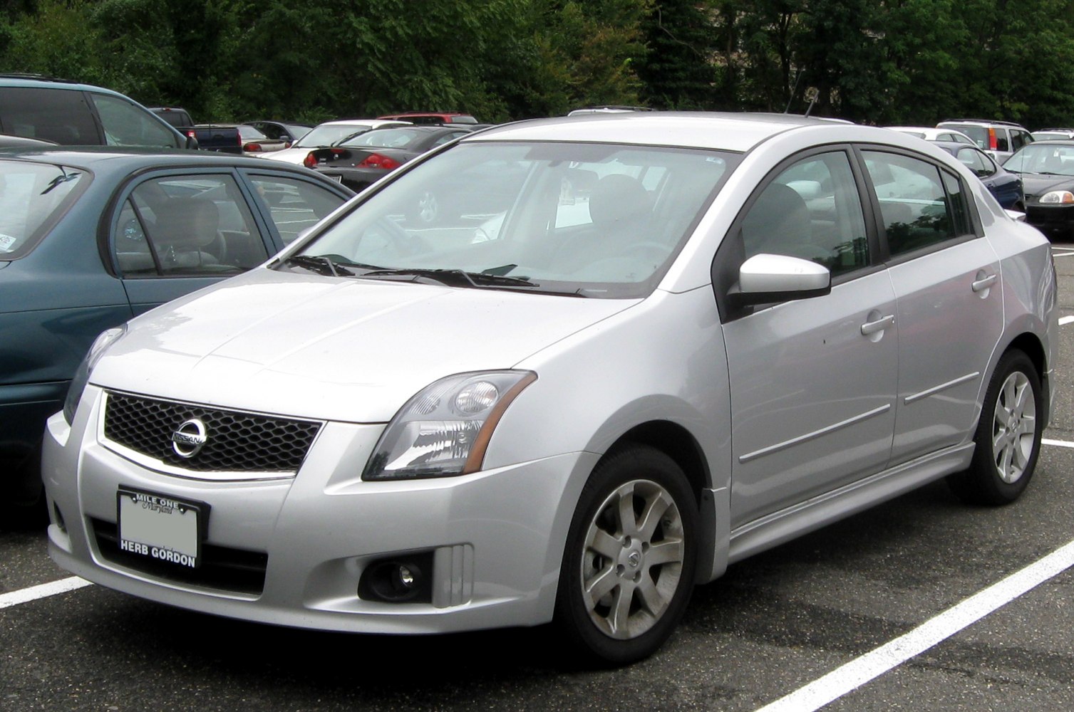 Silver compact sedan with distinctive headlights and alloy wheels