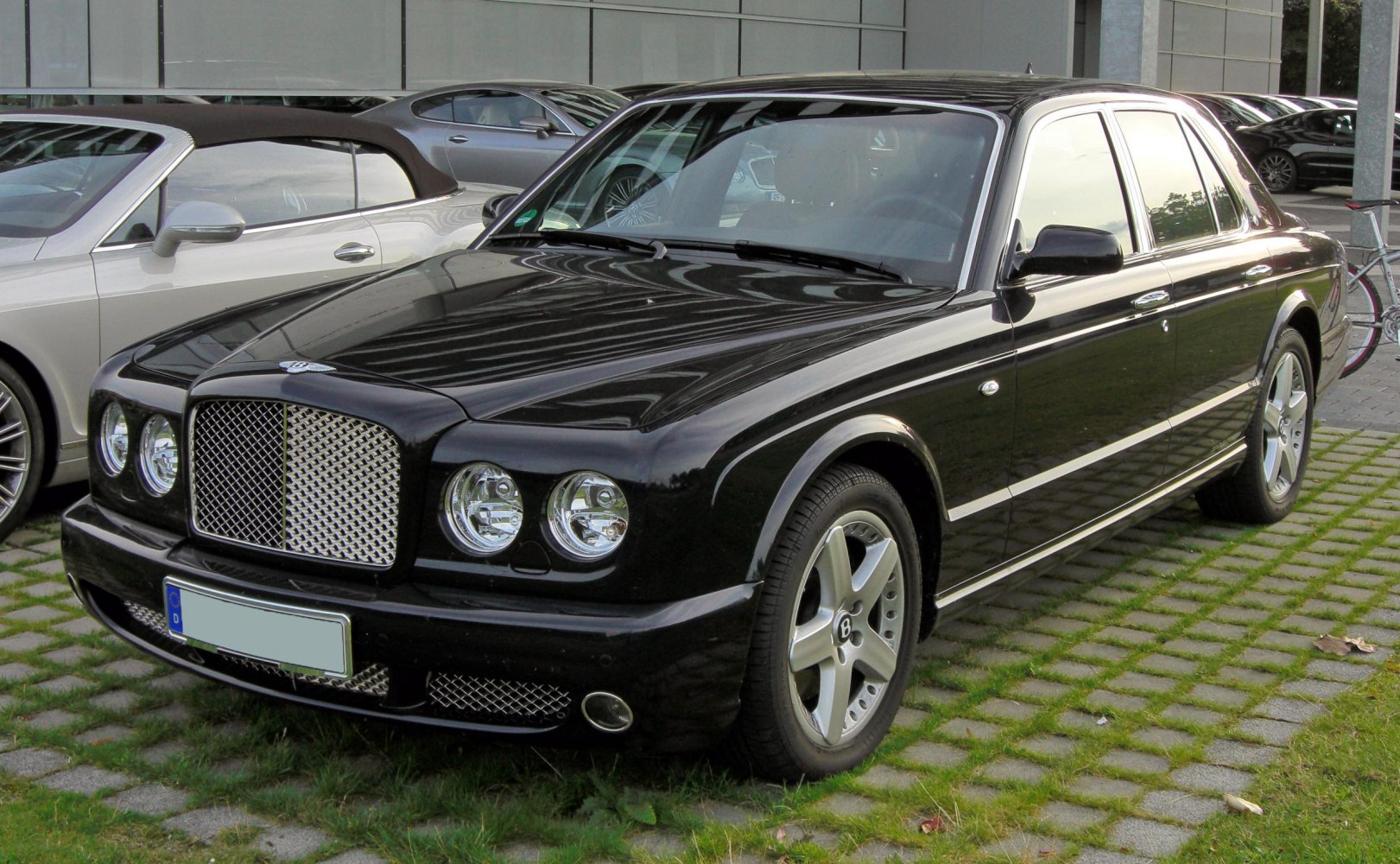 Front angled view of luxury sedan with iconic grille and round headlights