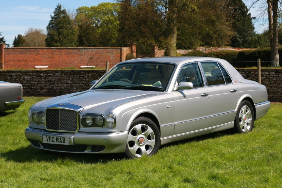 Front-side view of a silver luxury sedan with classic grille and alloy wheels.