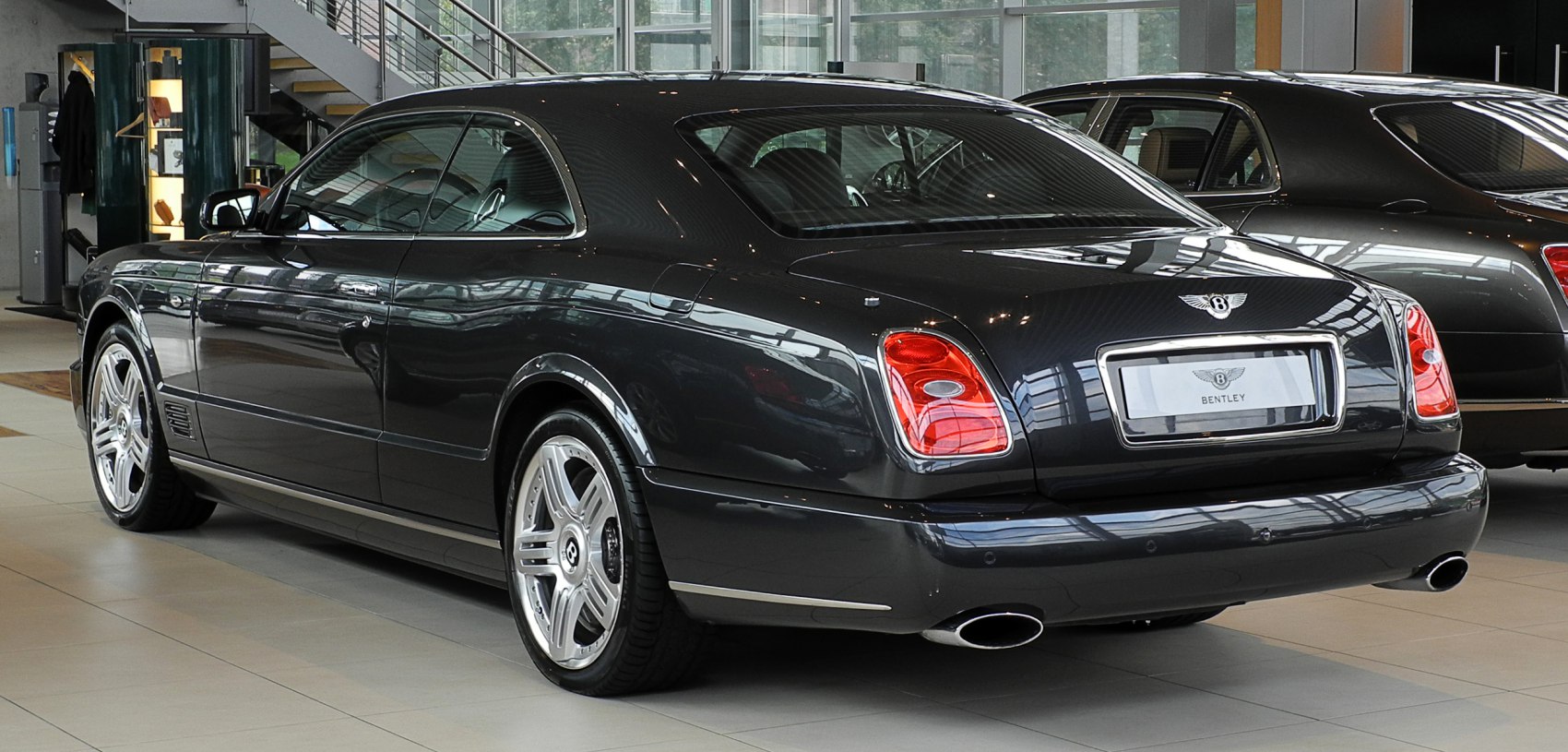 Luxury coupe rear profile with tail lights and dual exhaust pipes
